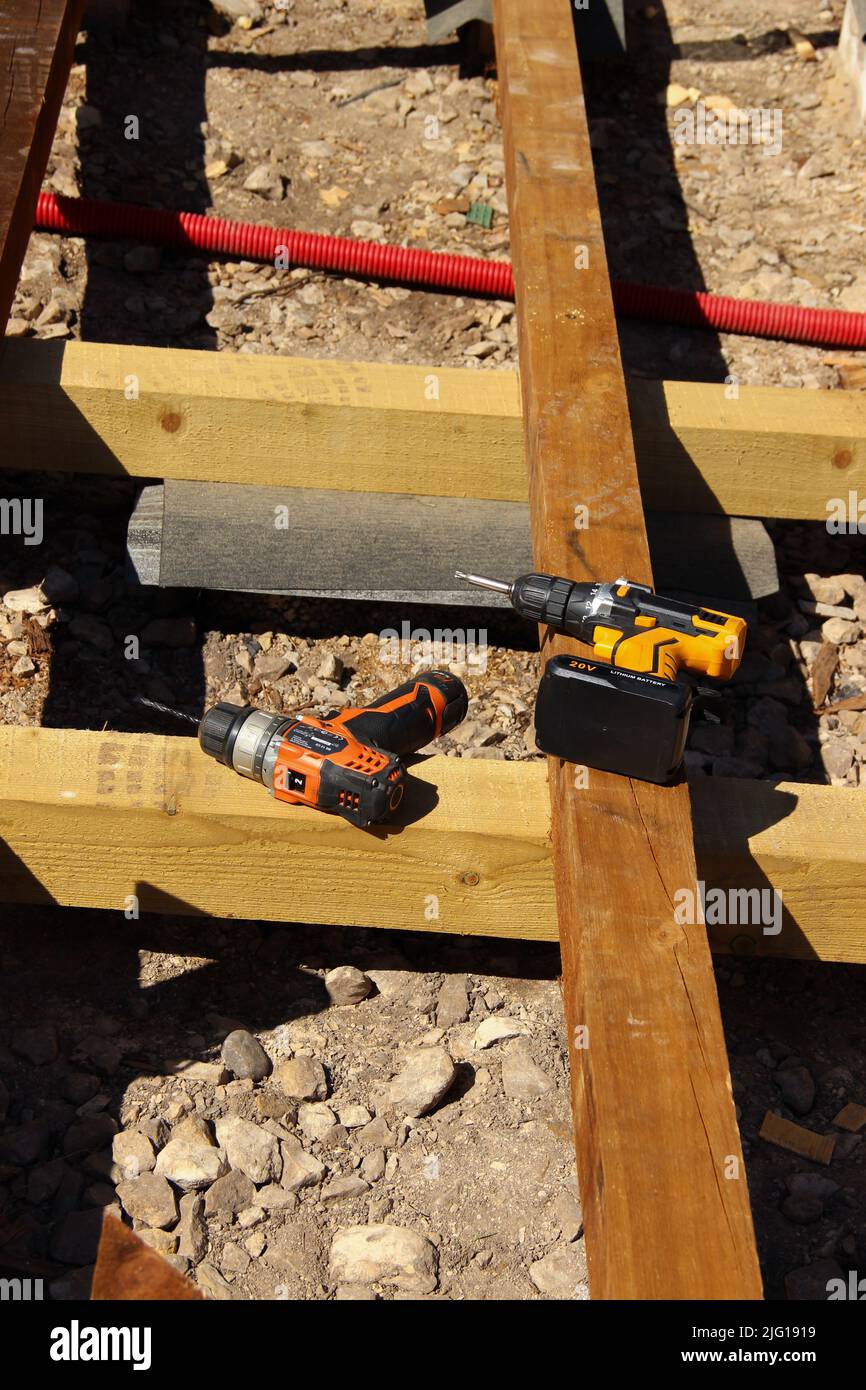 Cacciaviti poggiati su una trave in legno. Riparazione del ponte in corso. Foto Stock