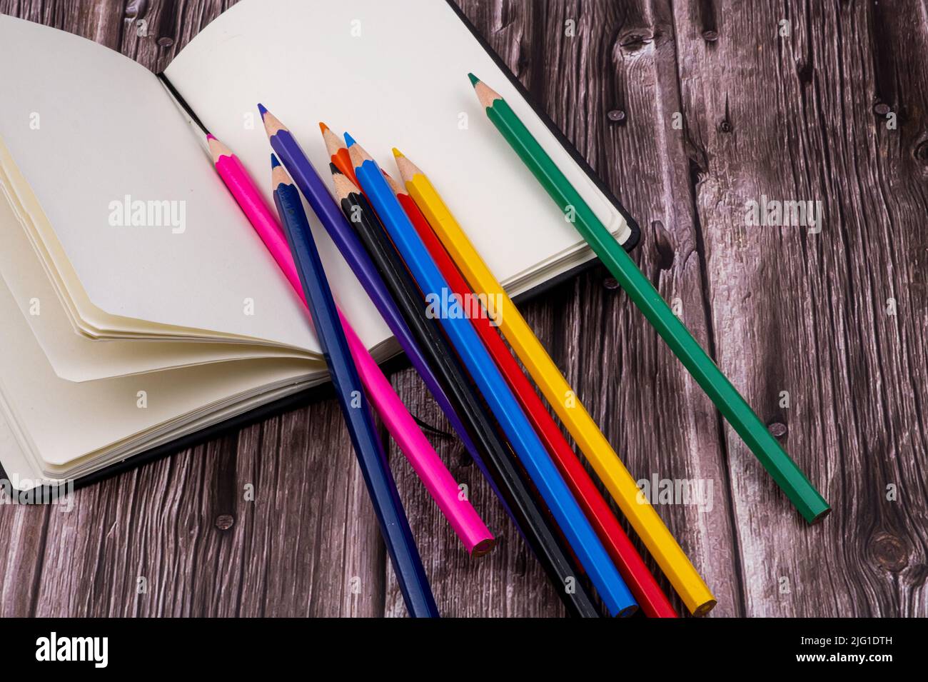 Varie forniture scolastiche come pennarelli, penne colorate e pennarelli, notebook e cancellatore. Sulla parte superiore di un tavolo di legno. Torna a scuola. Foto Stock