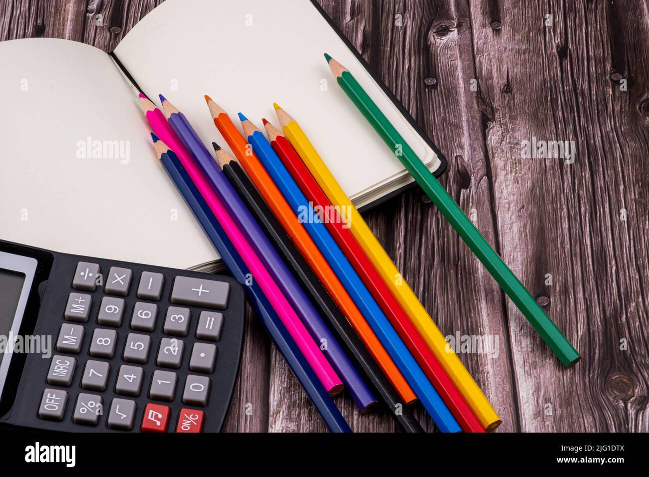 Varie forniture scolastiche come pennarelli, penne colorate e pennarelli, notebook e cancellatore. Sulla parte superiore di un tavolo di legno. Torna a scuola. Foto Stock