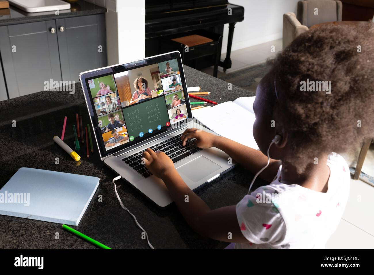 Ragazza afroamericana con capelli afro che studiano in classe online oltre la videochiamata sul portatile a casa Foto Stock