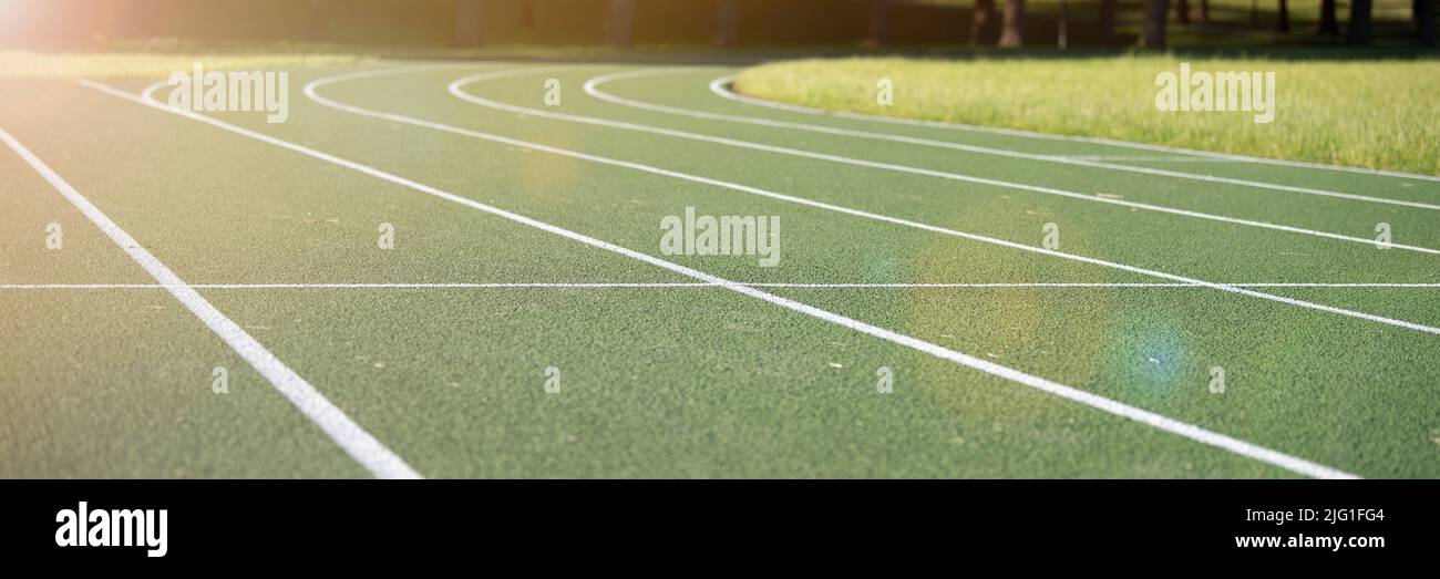 Pista da corsa allo stadio. Rivestimento in gomma verde. Pista da corsa all'aperto nel parco, estate Foto Stock