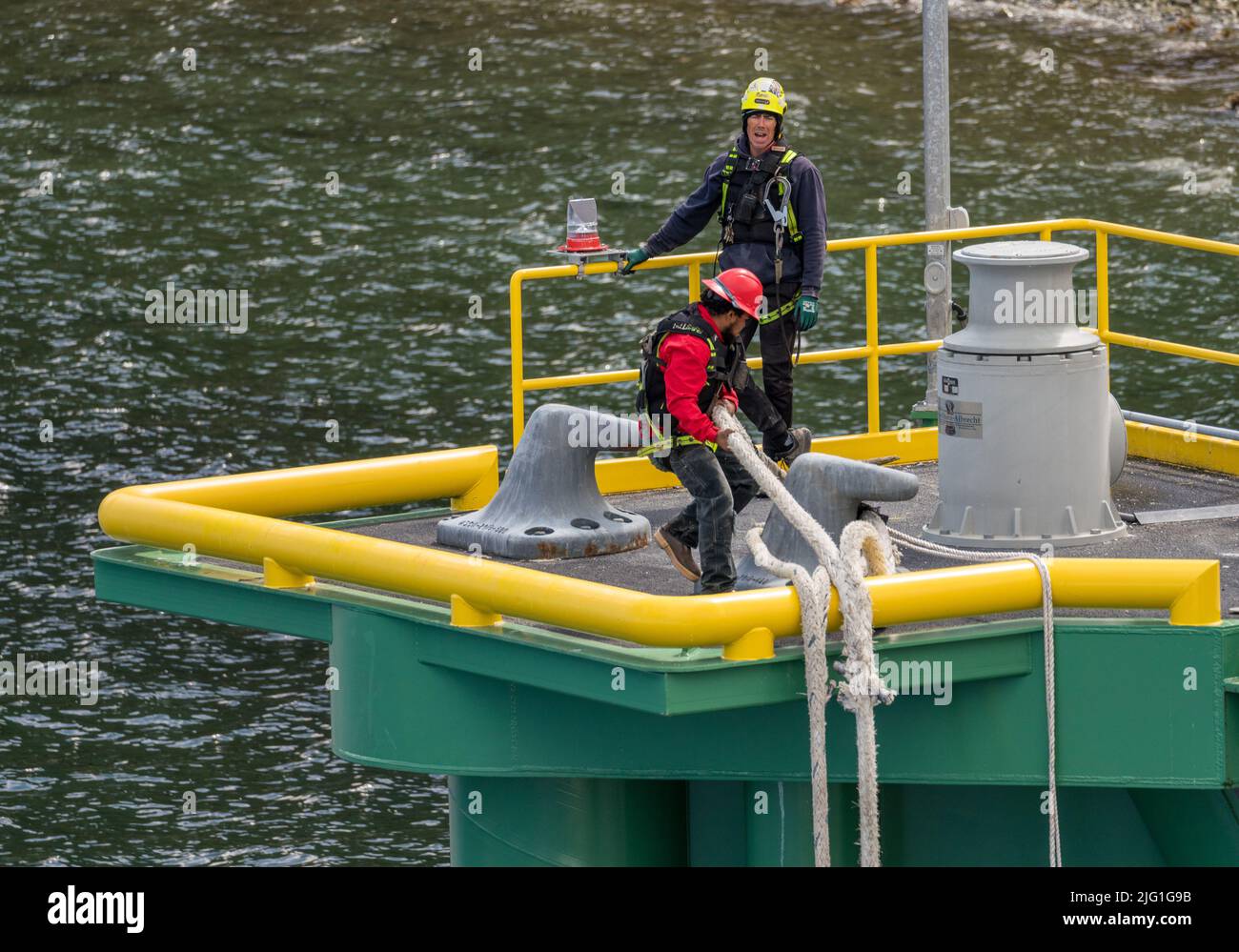 Skagway, AK - 6 giugno 2022: Lavoratori portuali che trasportano le funi pesanti per fissare la nave da crociera al porto Foto Stock