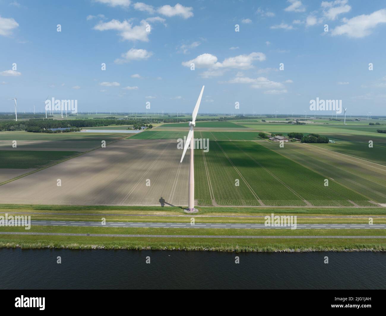 Sistema di turbine eoliche generazione di energia sostenibile in un parco eolico in campagna. Infrastrutture di produzione di energia rinnovabile pulite e verdi. Foto Stock