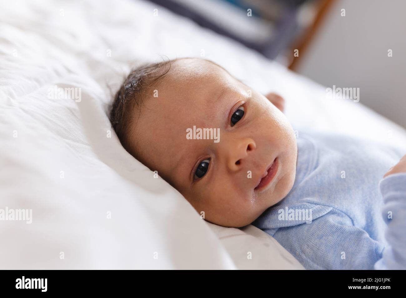 Piano di superficie ritratto primo piano di carino caucasico neonato bambino sdraiato sul letto a casa, copia spazio Foto Stock
