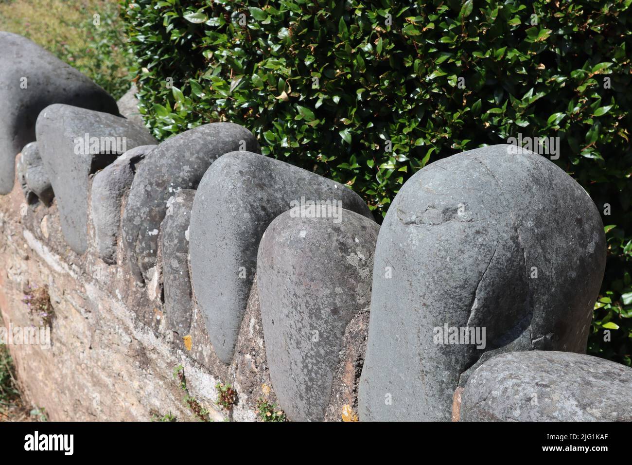Grandi pietre rotonde cementate alla parte superiore di un muro come finitura ornamentale Foto Stock