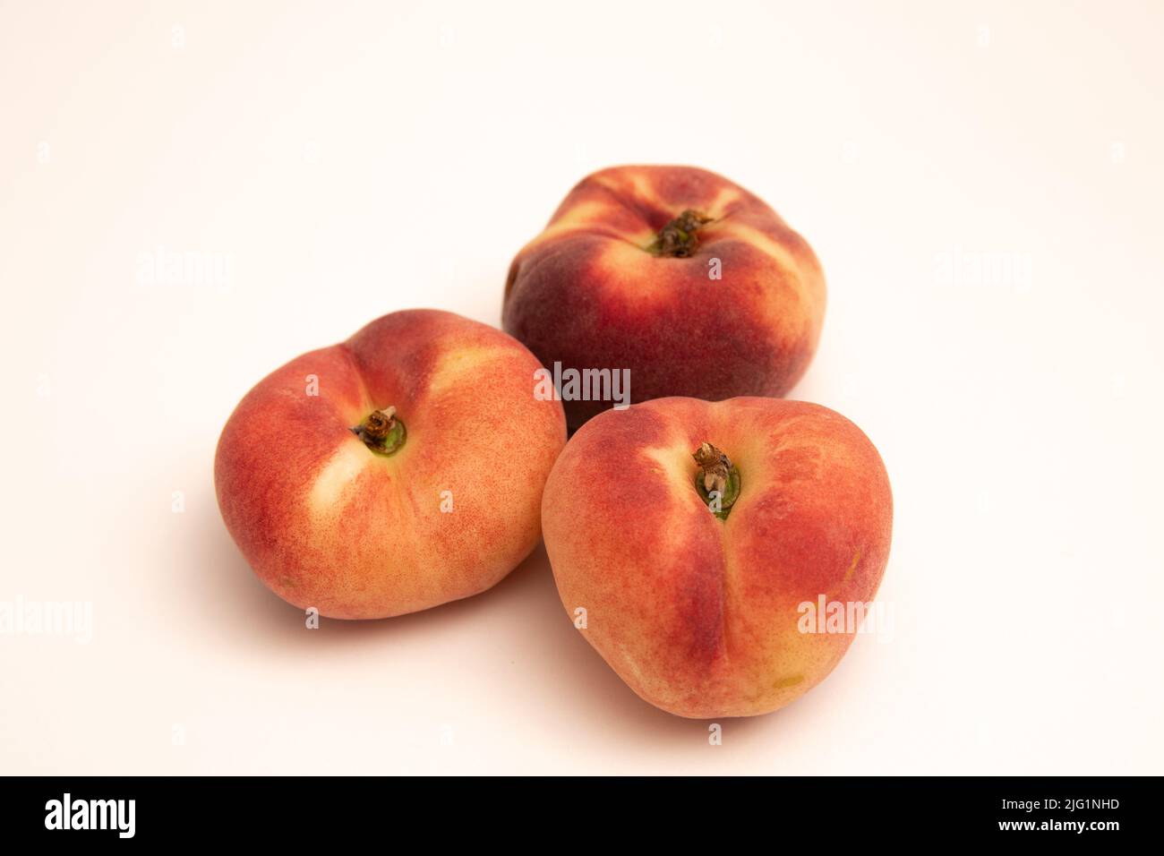 Pesche di ciambella davanti ad uno sfondo bianco giallastro Foto Stock