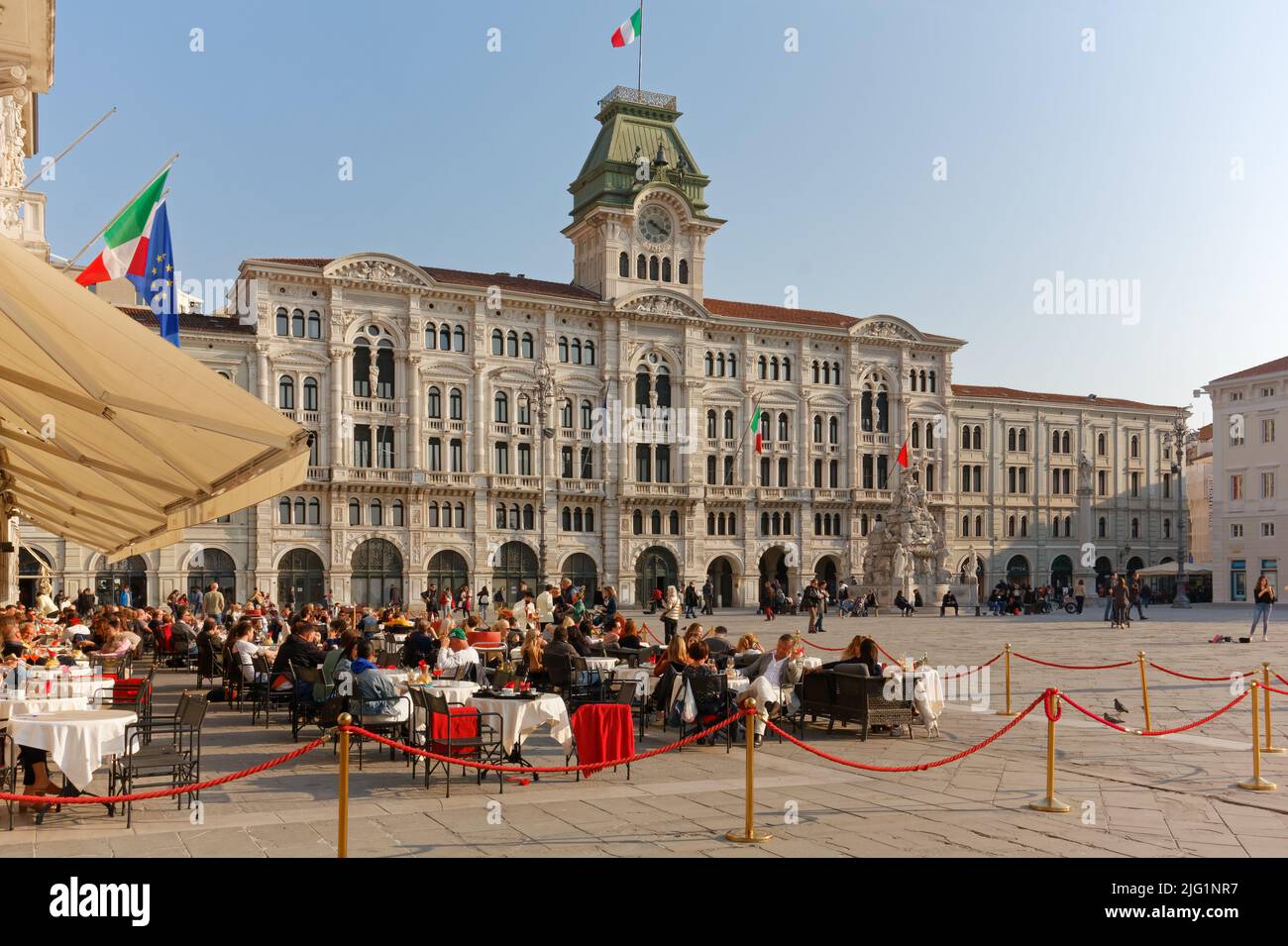 TRIESTE, Italia - 25 marzo 2022: Affollate tavole del caffè degli specchi in Piazza Unità d'Italia, piazza principale della città Foto Stock