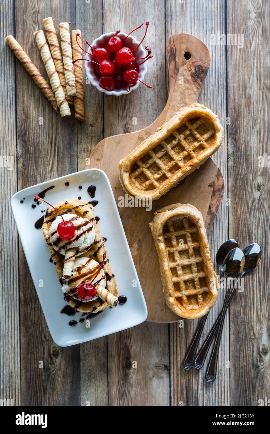 Cialde a base di zoccoli conditi con ciliegie di maraschino e salsa al cioccolato. Foto Stock