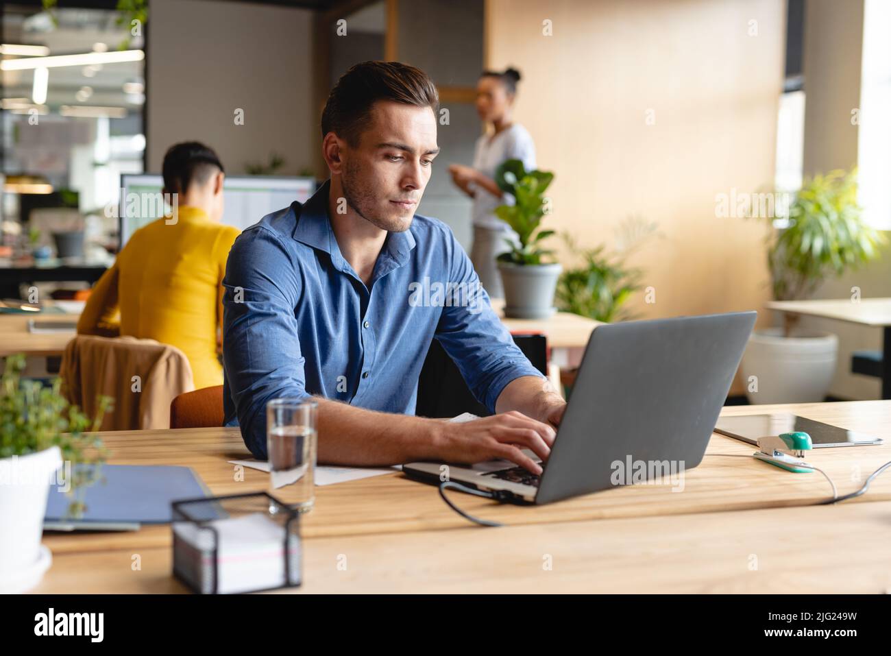 Giovane uomo d'affari caucasico che lavora su un notebook in ufficio creativo Foto Stock