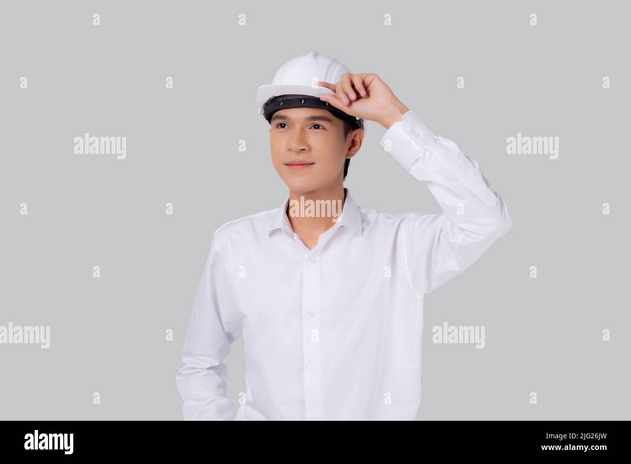 Ritratto giovane asiatico uomo è ingegnere indossare casco in piedi e sorridente con sicuro isolato su sfondo bianco, bello maschio è architetto o co Foto Stock