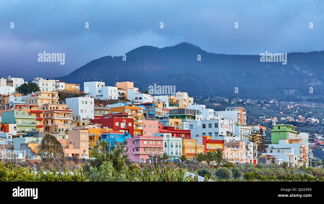 Edifici colorati a Santa Cruz de la Palma con spazio copia. Bellissimo paesaggio urbano con montagne dai colori vivaci e nuvole sovrastanti. Una vacanza vivace Foto Stock