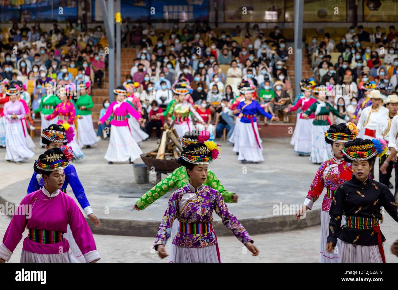 LIJIANG, CINA - 7 LUGLIO 2022 - i residenti di Mosuo in costumi etnici ballano per i turisti durante una festa di falò al lago di Lugu a Lijiang, provincia di Yunnan, Foto Stock