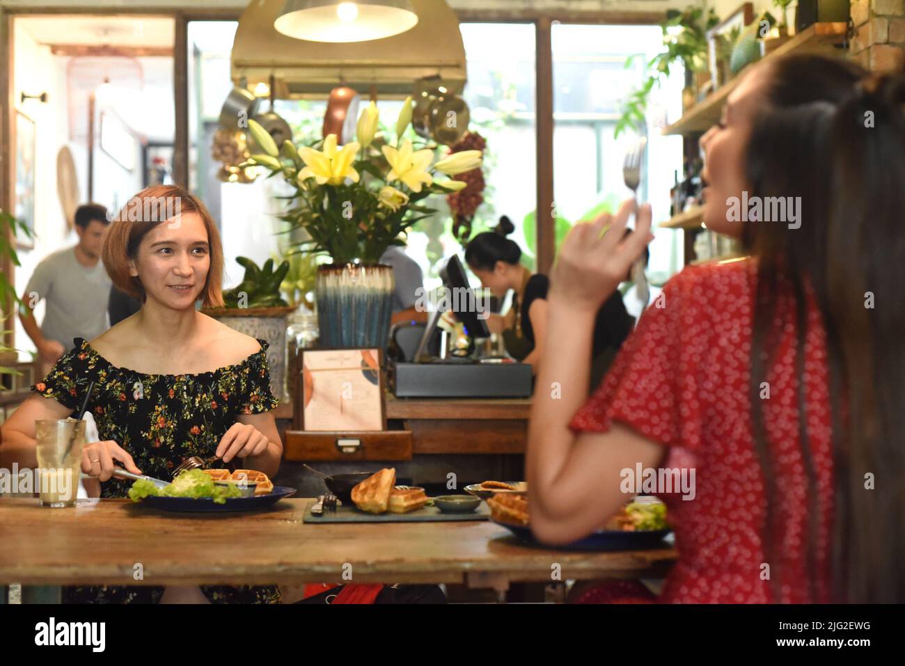 Le giovani donne comunicano tra loro in un bar Foto Stock