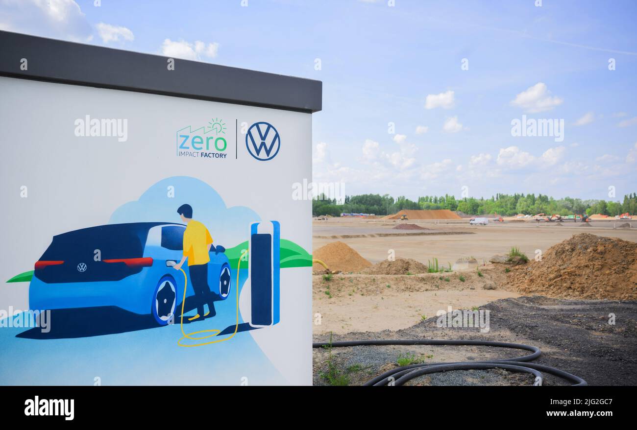 Salzgitter, Germania. 18th maggio 2022. Una foto su un muro dello stabilimento VW Salzgitter mostra un atterraggio di un'auto elettrica vicino a un grande cantiere. Volkswagen sta costruendo una fabbrica di celle a batteria nello stabilimento di Salzgitter per la sua prevista produzione su larga scala delle celle a batteria proprie del Gruppo. Presso il centro di ricerca e sviluppo sono già in fase di sviluppo nuovi sistemi di batterie per le auto elettriche. Credit: Julian Stratenschulte/dpa/Alamy Live News Foto Stock