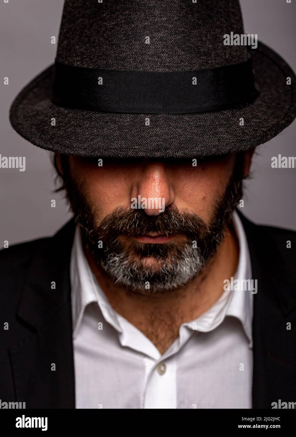 Misterioso uomo barbuto con il volto nascosto da un cappello Foto Stock