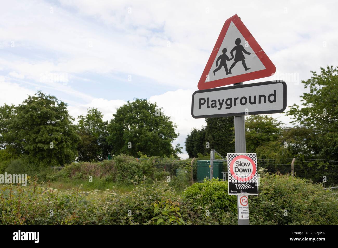 Un cartello stradale britannico indica che i bambini vanno da o verso la scuola o un parco giochi davanti. Il segno è fissato ad un lampione Foto Stock