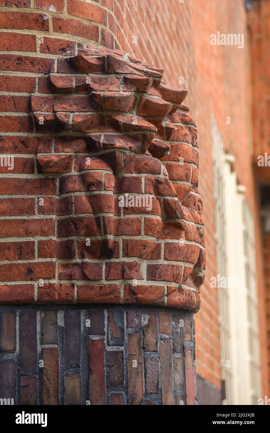 Amsterdam, Paesi Bassi. Giugno 2022. Dettagli delle facciate del caratteristico edificio in mattoni del complesso residenziale con arco in stile scuola di Amsterdam Foto Stock