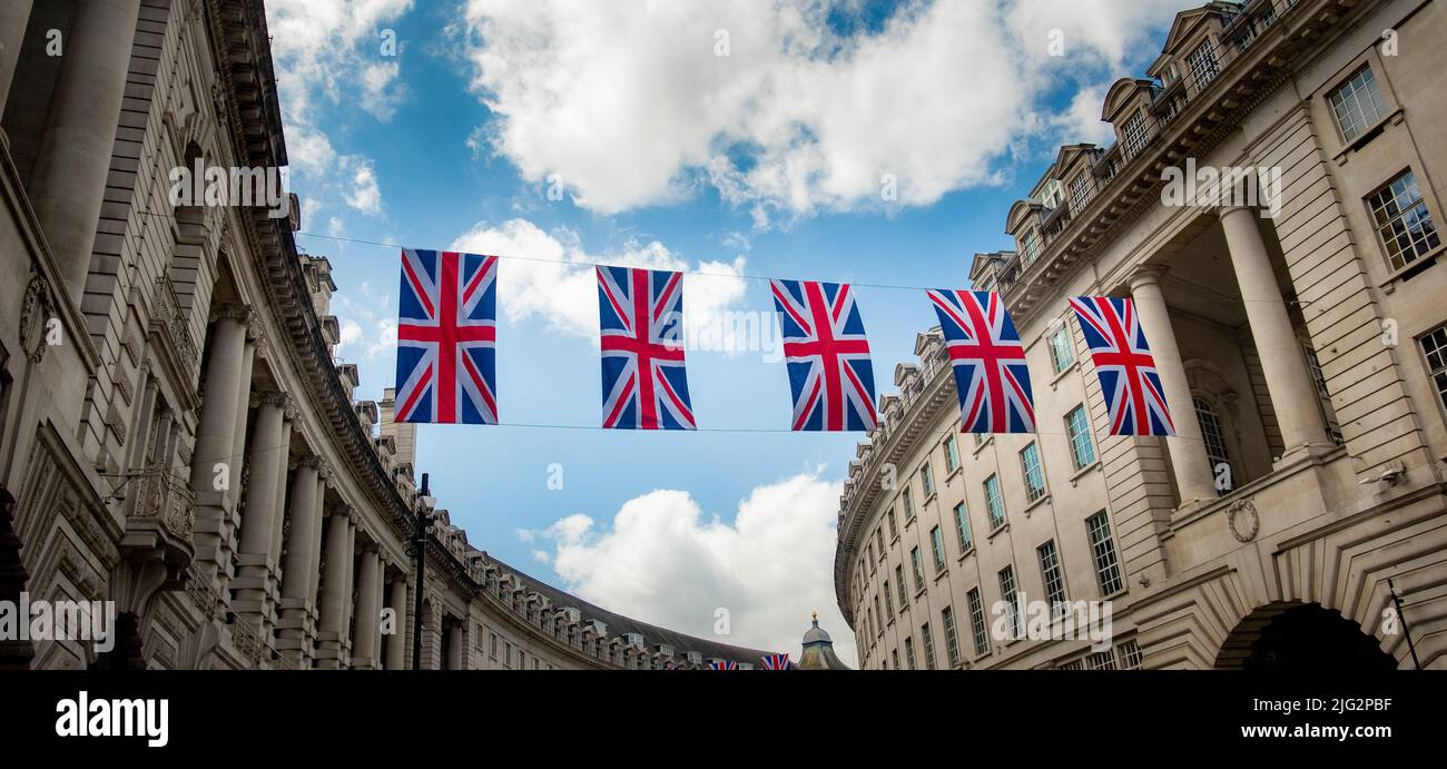 Londra 2022 giugno: Bandiere Union in mostra sopra Regent Street, una destinazione di shopping di riferimento nel West End di Londra Foto Stock