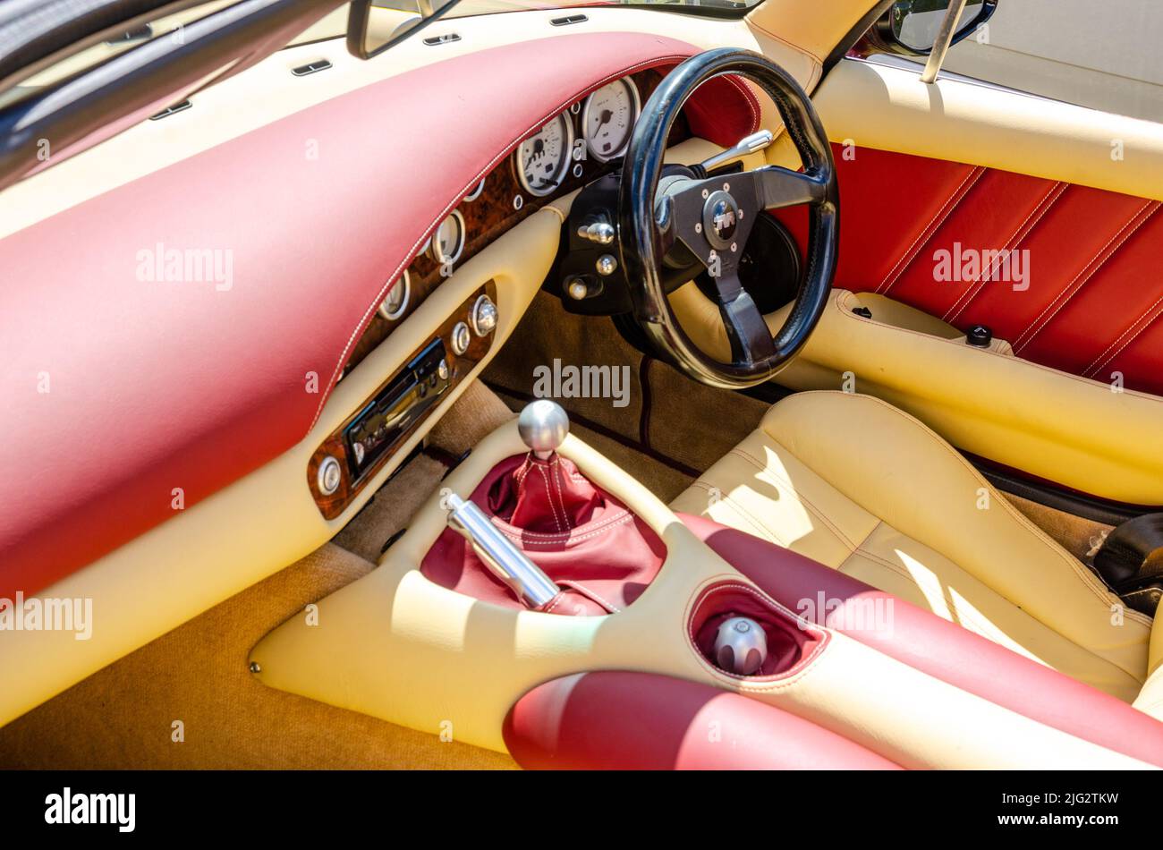 Interni in pelle color rosso e crema con volante, leva del cambio e altri comandi di un TVR Chimera al Berkshire Motor Show di Reading, Regno Unito Foto Stock