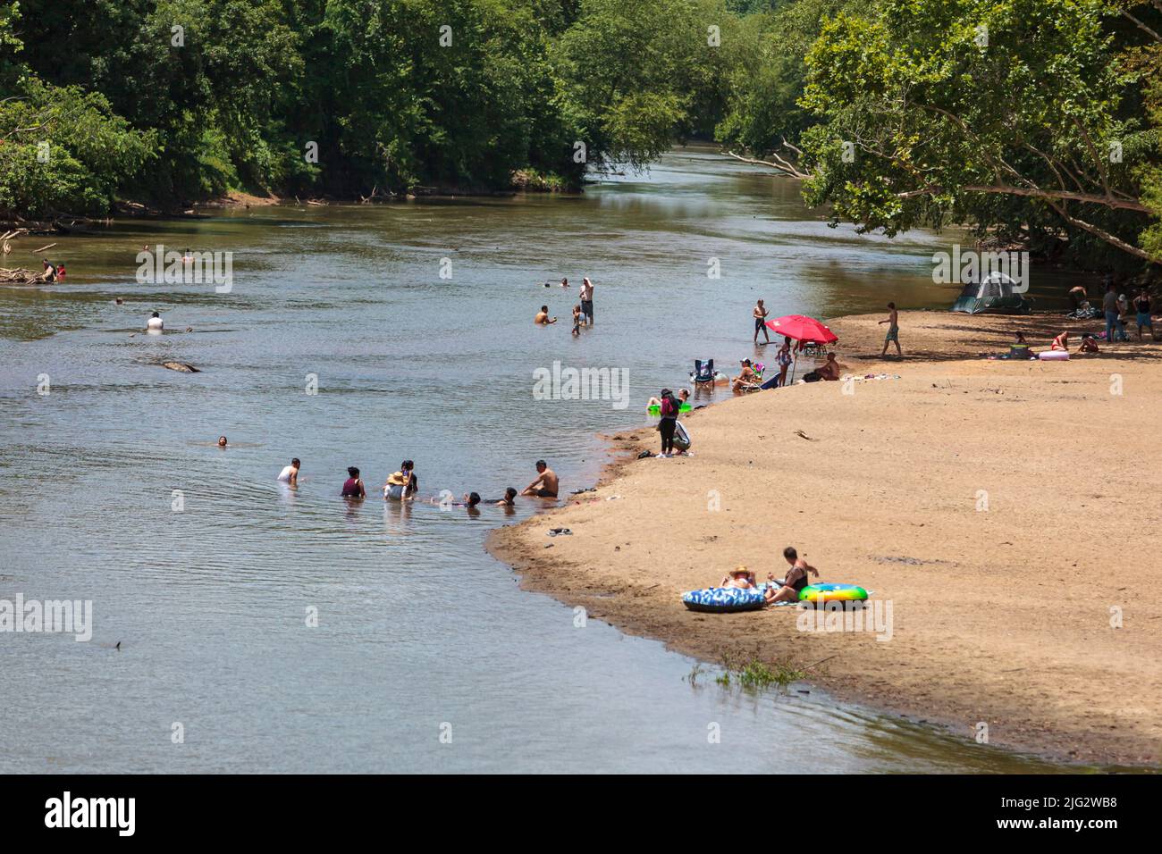 Con temperature calde e bassi livelli d'acqua, gruppi di persone nuotano nel fiume Wolf per sfuggire all'ondata di calore a Memphis, Tennessee. Su Ju Foto Stock