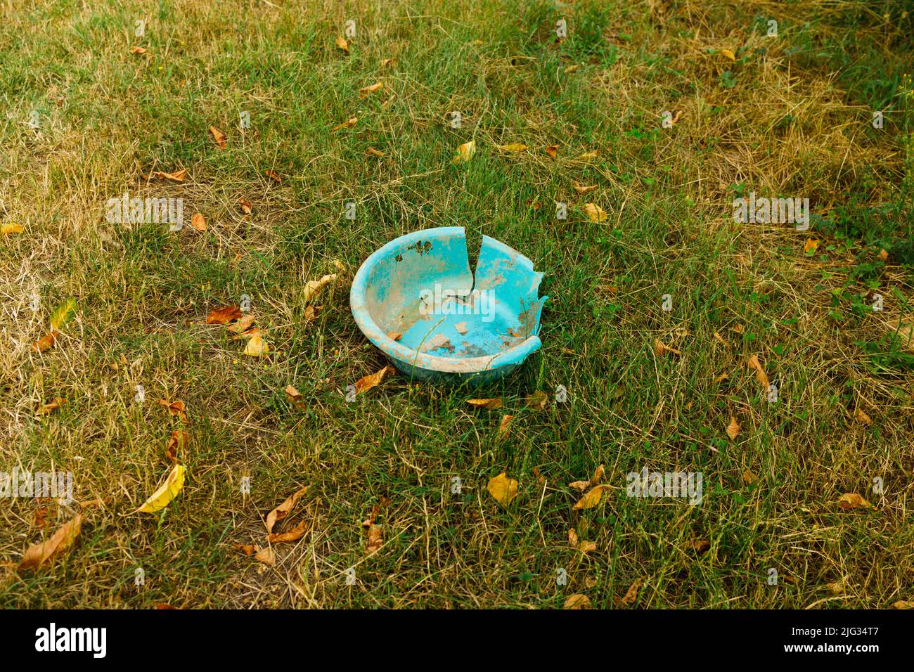 Un vecchio washbowl blu inquinante l'ambiente e lentamente decomponendo sotto il tempo Foto Stock