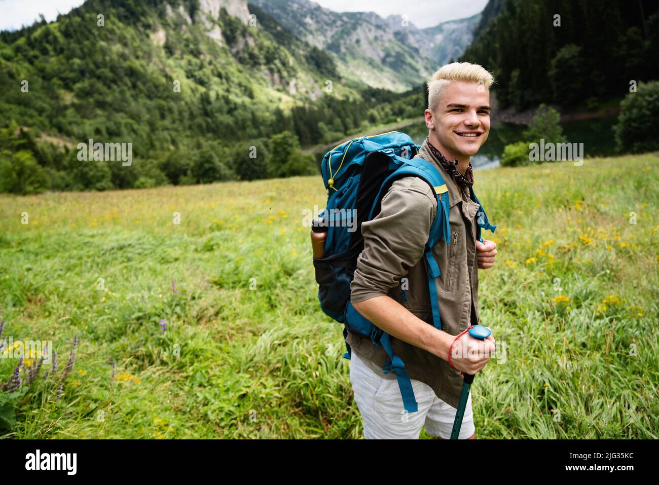 Avventura uomo trekking montagna selvaggia con zaino Foto Stock