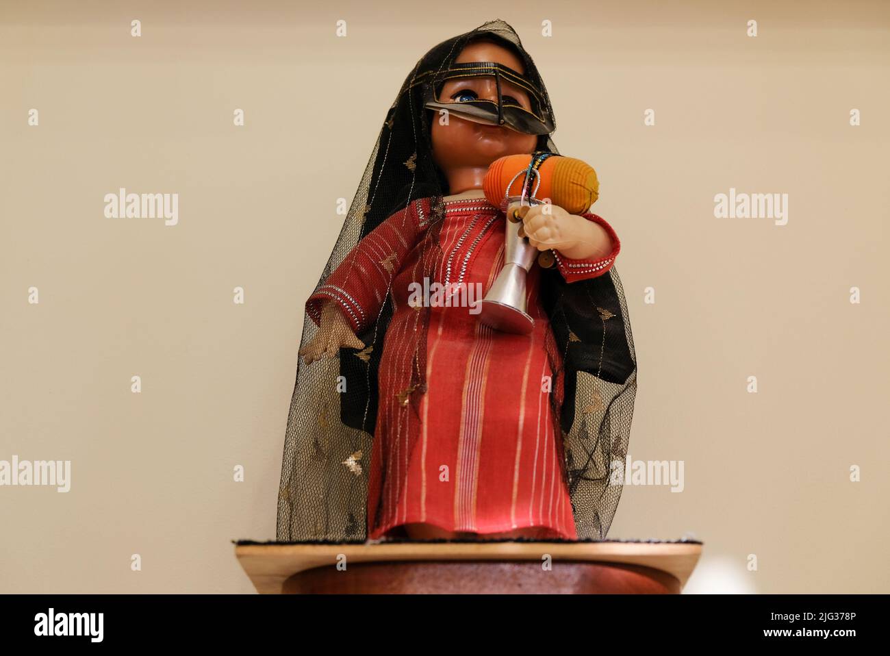 Bambola femminile che indossa Shayla e Omani Burqa, entrambi abiti tradizionali arabi, e che tiene un Mabkhara per Bakhoor. Decorazioni a parete in una casa degli Emirati. Foto Stock