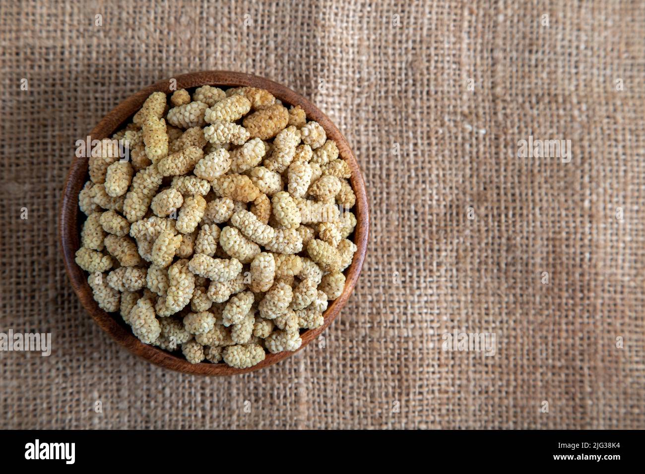 Ciotola piena di gelso secco su un fondo di tessuto Foto Stock