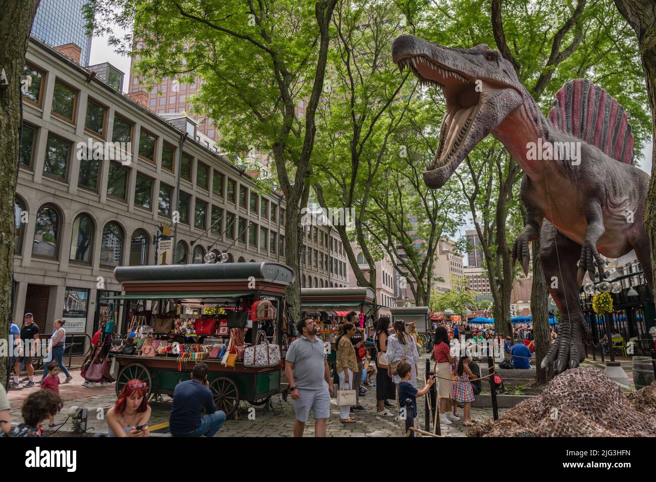 Boston, ma, US-Giugno 11, 2022: Persone al mercato alimentare e destinazione turistica del centro con grande statua di dinosauro sullo sfondo. Foto Stock