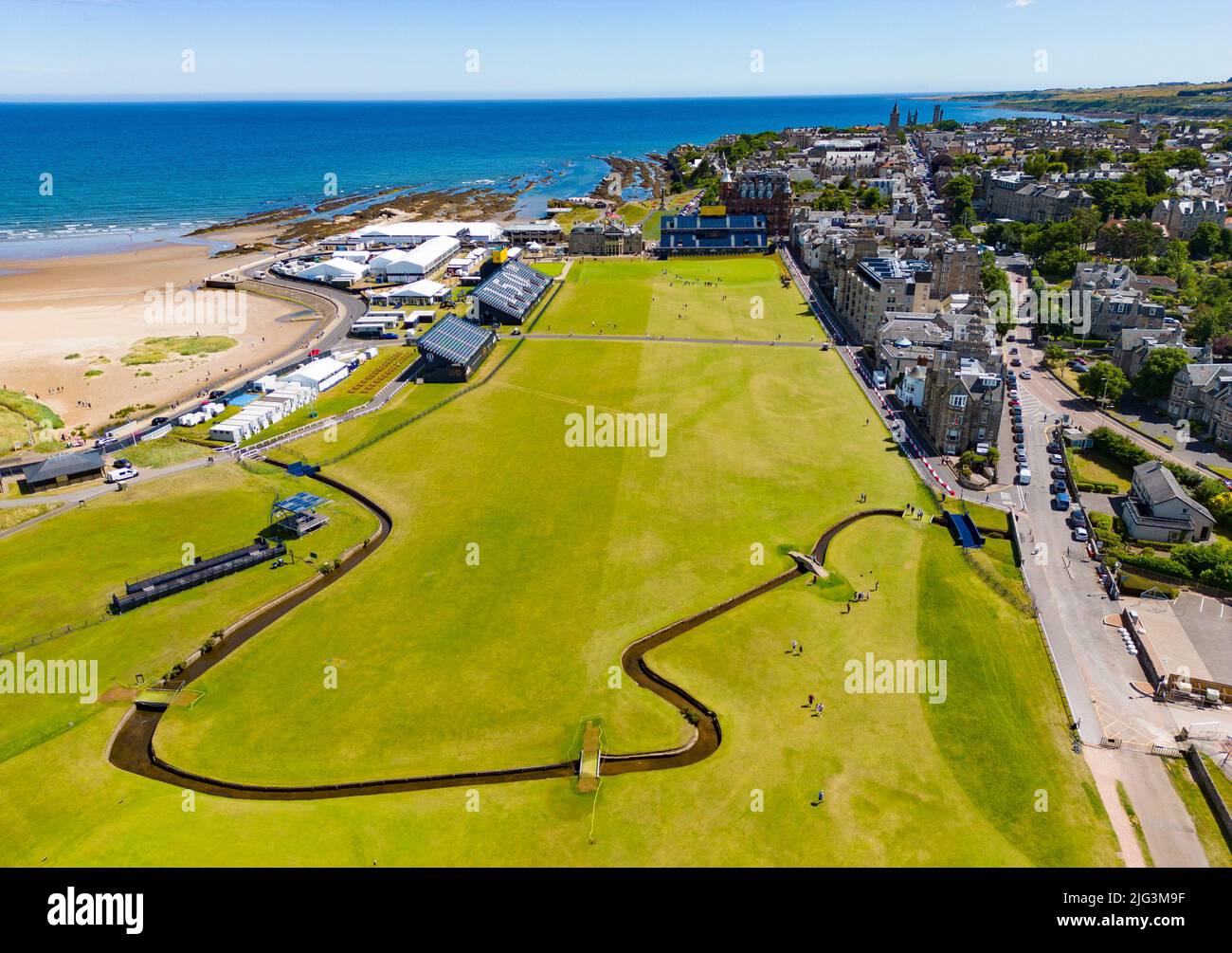 St Andrews, Scozia, Regno Unito. 7 luglio 2022. L'Old Course a St Andrews è un alveare di attività con una settimana per andare fino al primo round del campionato Open 150th. I membri del pubblico sono autorizzati a camminare sui fairway perché il campo Vecchio è un parco pubblico. I turisti hanno ottenuto il massimo da questo accesso per posare per fotografie oltre a famose caratteristiche come il ponte di Burn di Swilken sulla 18th buche. PIC; vista aerea lungo il fairway del 18th attraverso il Burn di Swilken. Iain Masterton/Alamy Live News Foto Stock
