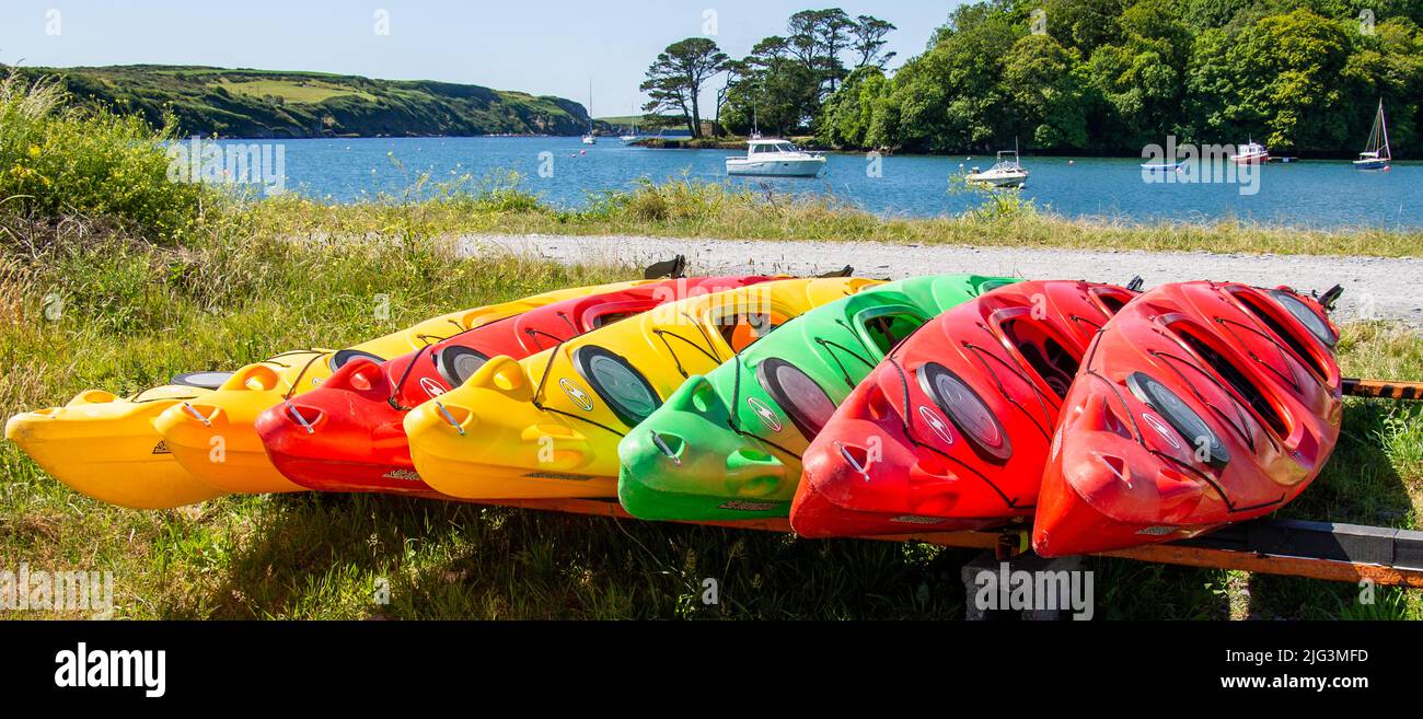 Kayak rossi, gialli, verdi tirati in fila Foto Stock
