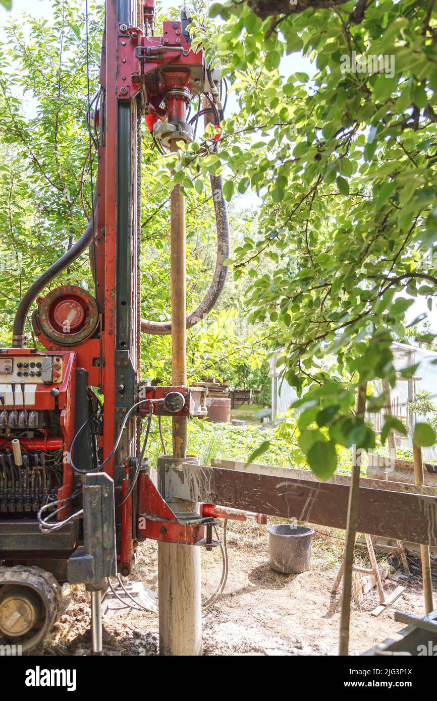 Foto di un carro di perforazione con un tubo per la perforazione di acqua potabile sullo sfondo di alberi caldo giorno di sole. Foto Stock