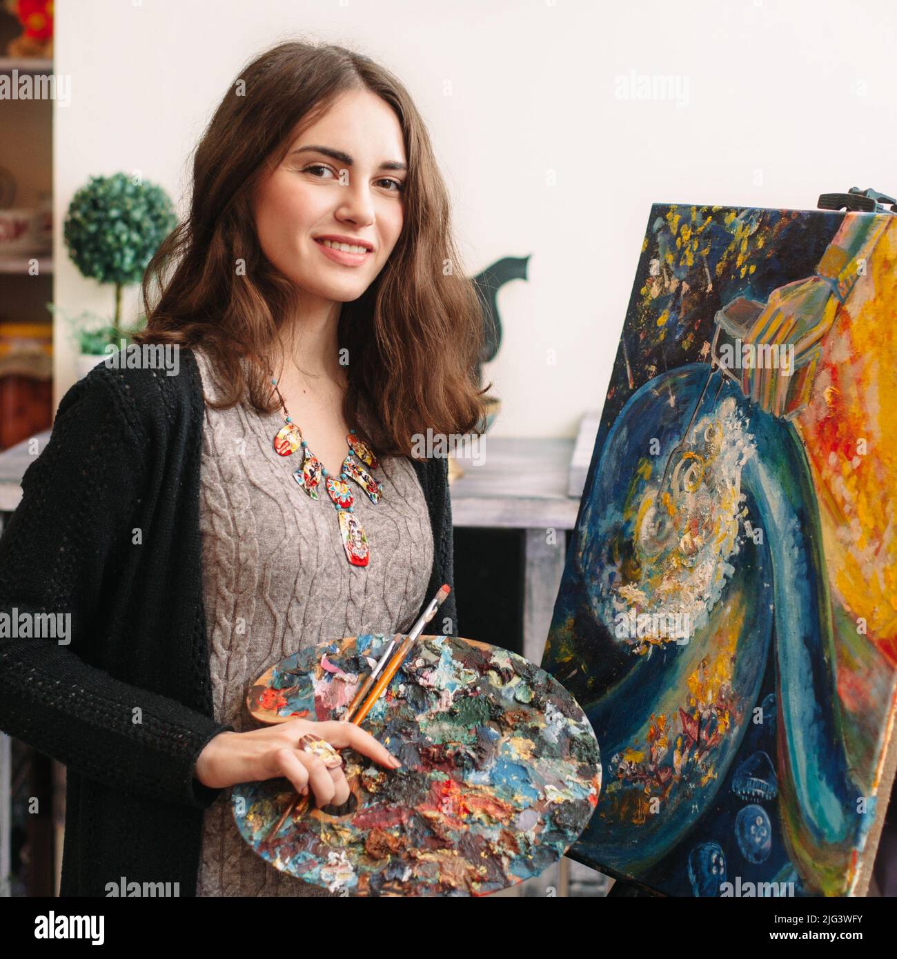 Creativo pittore felice dipinge un'immagine colorata Foto Stock