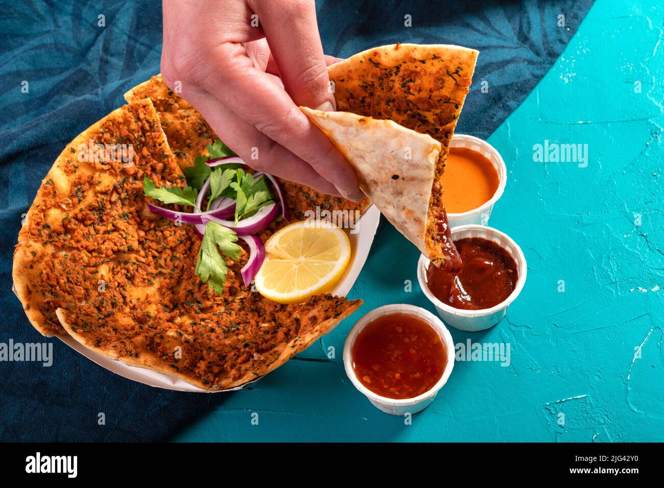 Tradizionale pizza marocchina con focacce condite con lenticchie rosse ed erbe servite con salse Foto Stock