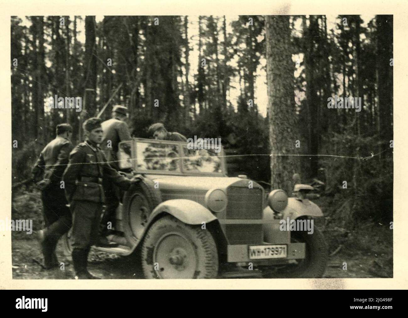 Ritratto di soldati divisionali con auto. Ritratto esterno di un gruppo divisionale vestire tedesco uniformità, con l'emblema Eagle sopra il guerriero e si trovano accanto ad una macchina convertita con registrazione: WH 179971 Foto Stock