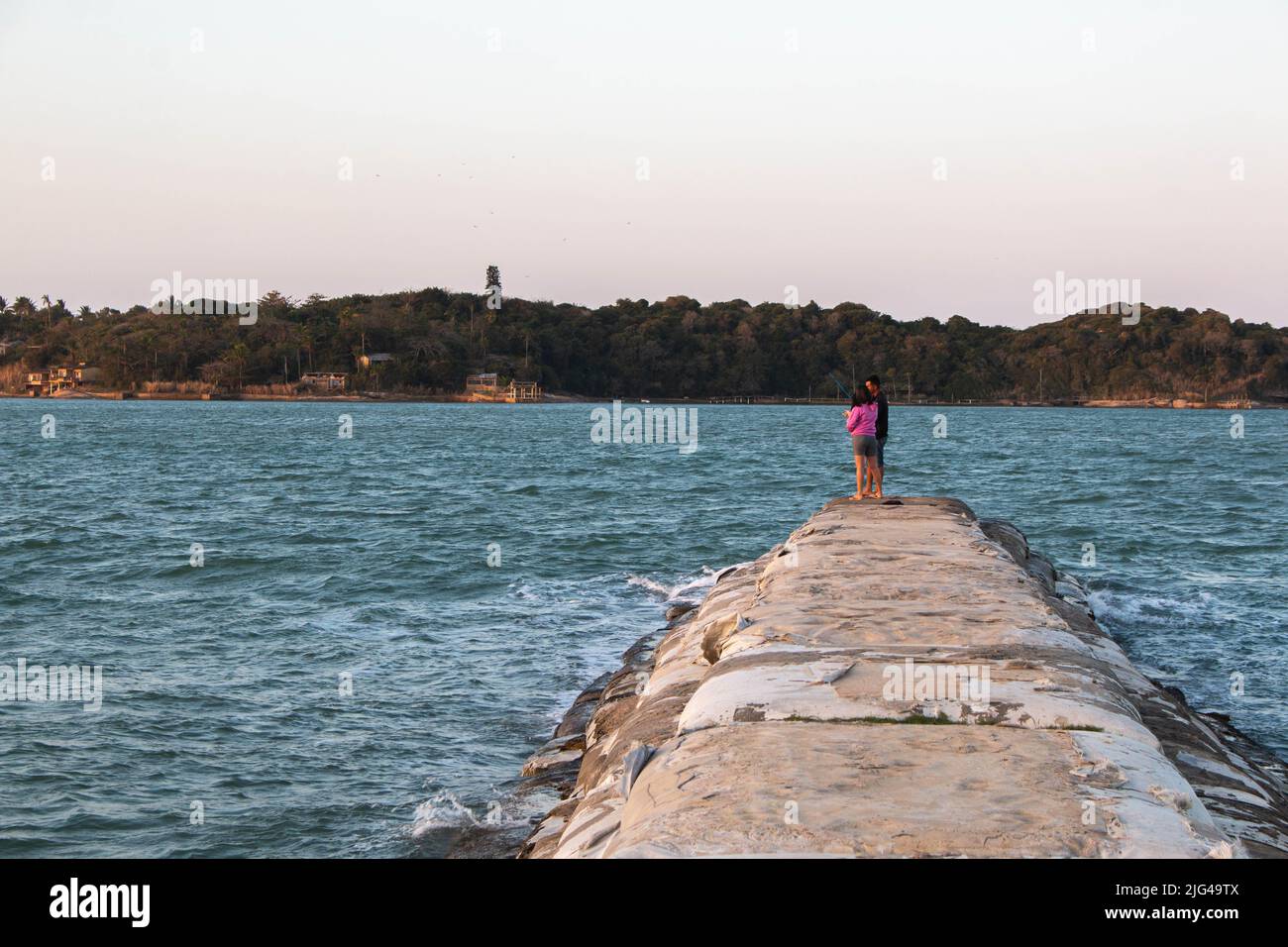 Canale tartaruga al tramonto con due persone che pescano a Buzios, Brasile. Pesca a Buzios, Brasile. Foto Stock