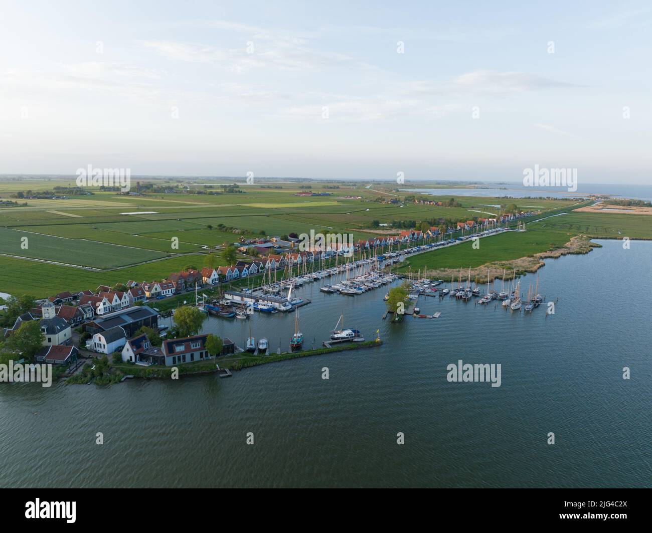 Durgerdam villaggio locale dike con vecchie case di legno tradizionale nel nord di Amsterdam. Porto paesaggio aereo di campagna marittima al tramonto Foto Stock