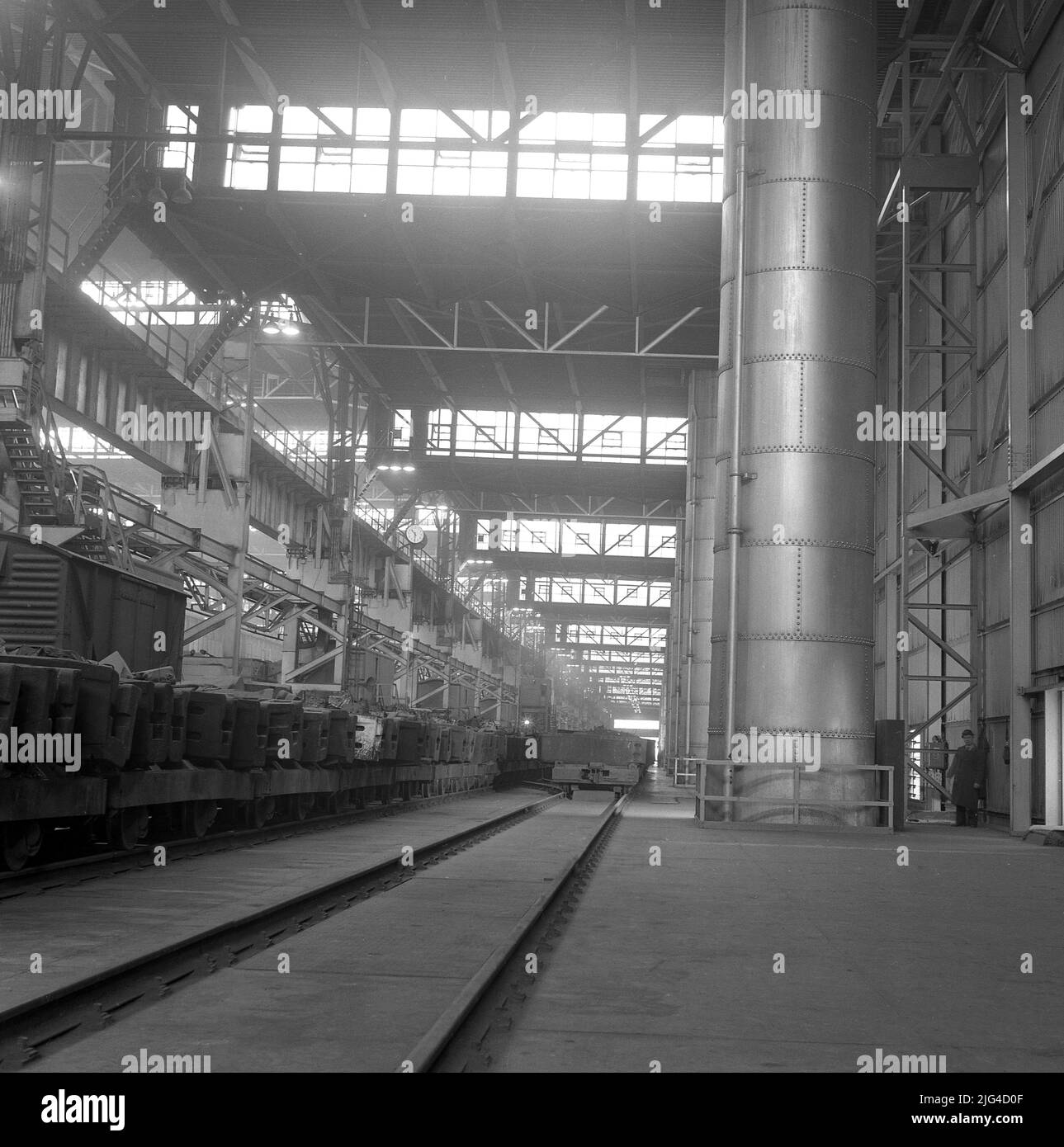 1950s, storico, all'interno di uno dei capannoni giganti dell'Abbey Steel Works, PortTalbot, Galles, Regno Unito, che mostra la pista ferroviaria che attraversa lo stabilimento. Foto Stock