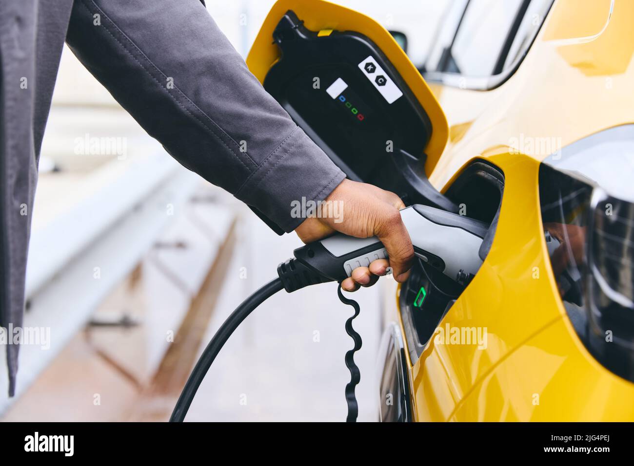 Inserimento manuale di un'auto elettrica all'esterno dell'ufficio in Car Park Charging Foto Stock