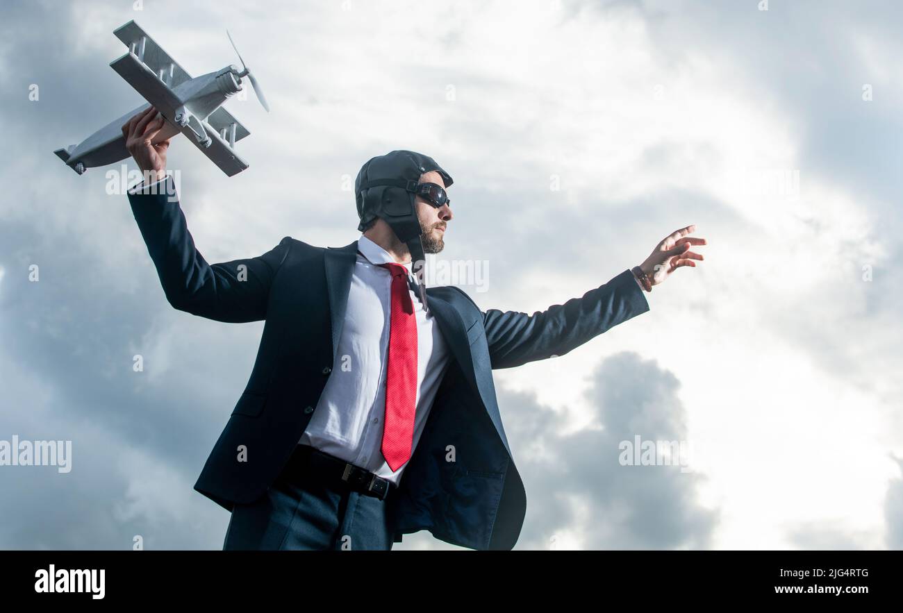 uomo d'affari in abito e cappello pilota lancia giocattolo aereo. avvio Foto Stock