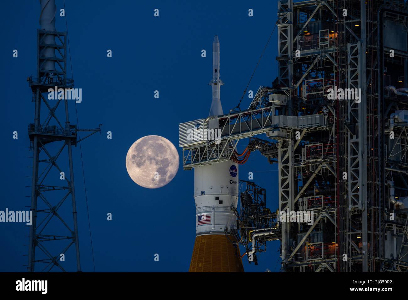 Una luna piena sorge sul razzo della NASA Artemis i Space Launch System con la navicella spaziale Orion a bordo di un lanciatore mobile al Launch Complex 39B, presso il Kennedy Space Center, 14 giugno 2022, a Cape Canaveral, Florida. SLS e Orion sono in fase di preparazione per una prova di vestito umido per mettere in pratica le tempistiche e le procedure di lancio. Foto Stock