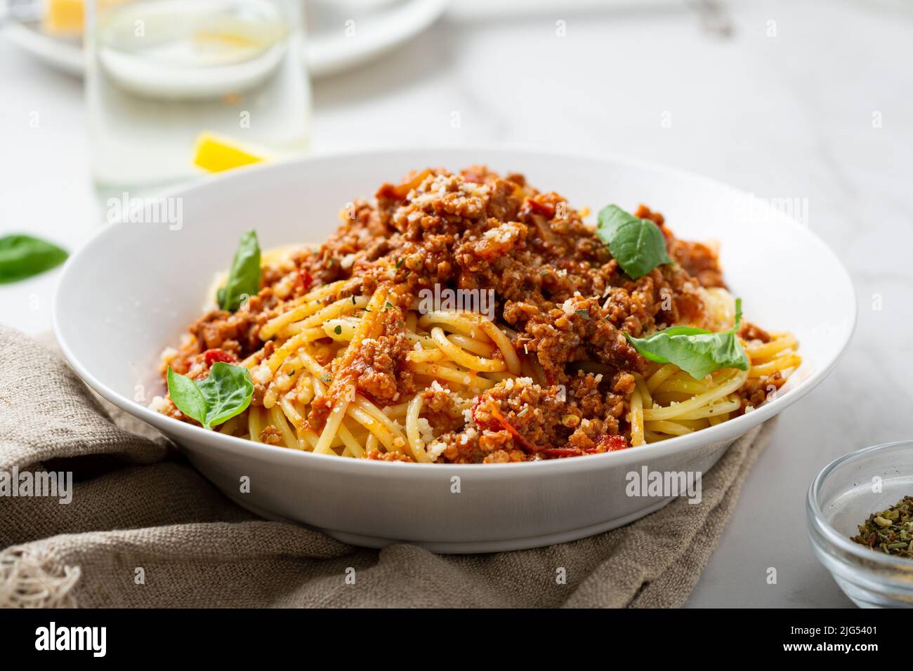 Primo piano di spaghetti di pasta con salsa di carne di bolognese su cibi leggeri da tavola Foto Stock