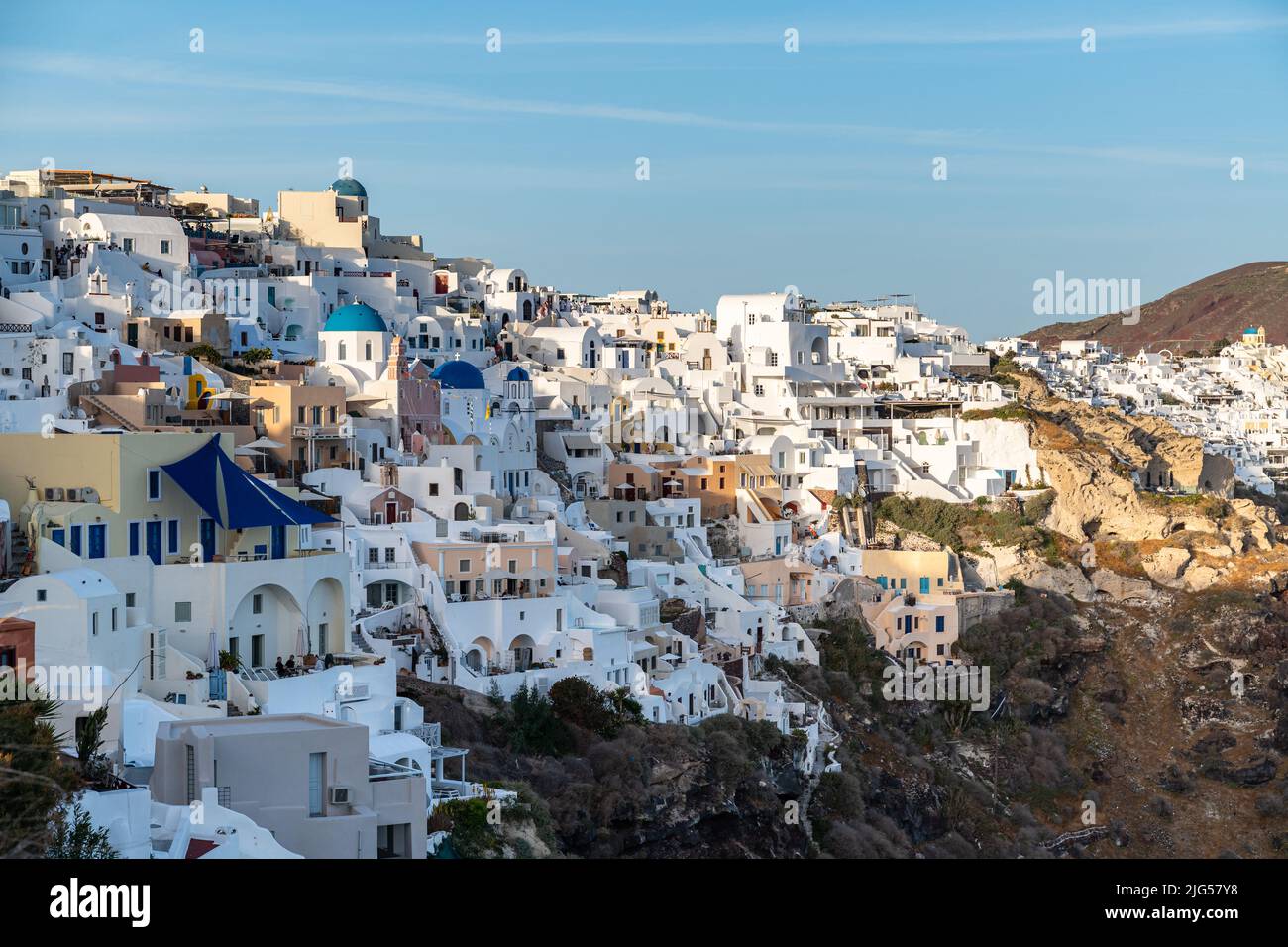 Vista di Oia con le sue famose case imbiancate di bianco che ospitano suite di hotel di lusso, Santorini, Grecia Foto Stock