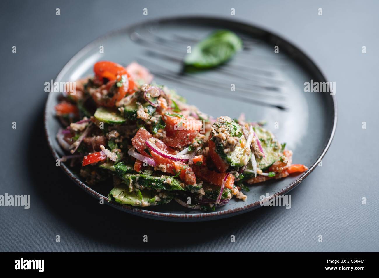 insalata georgiana con pomodoro fresco, cetriolo, cipolla e noce su sfondo nero Foto Stock