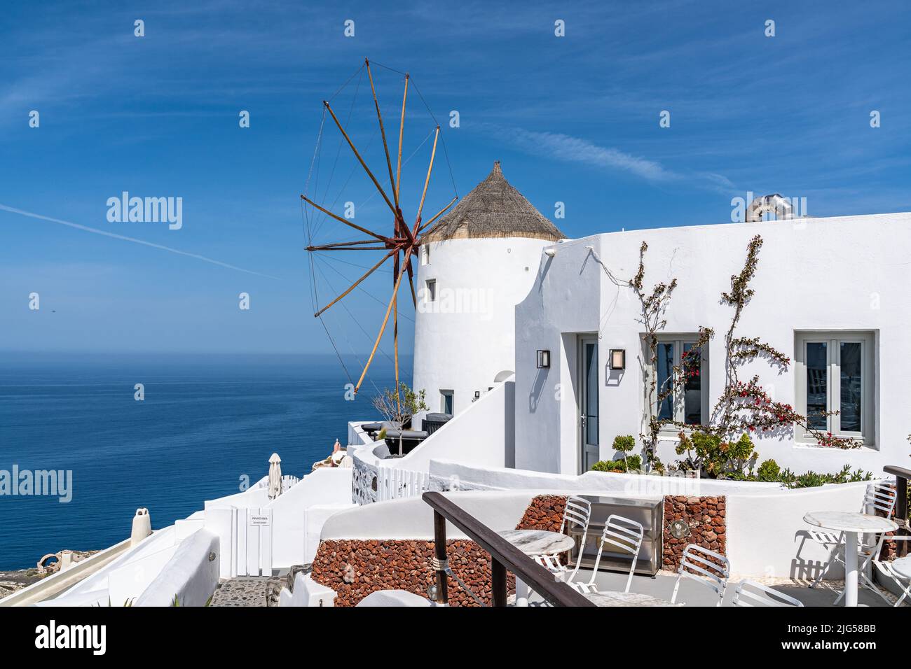 Iconico mulino a vento bianco a Oia con vista sul Mar Egeo, Santorini, Grecia Foto Stock