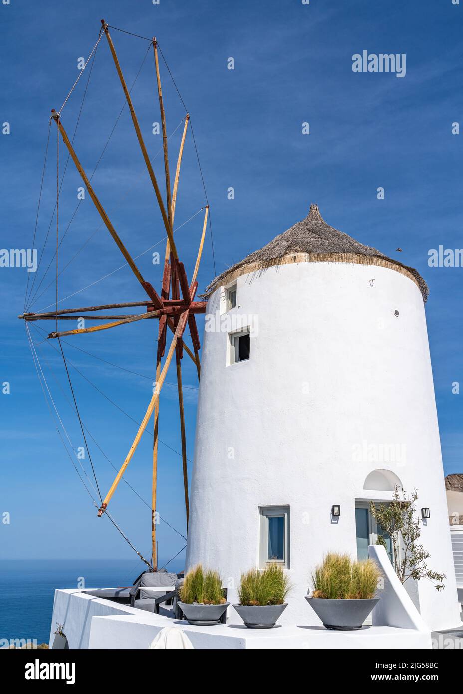 Iconico mulino a vento bianco nel villaggio di Oia, Santorini, Grecia Foto Stock