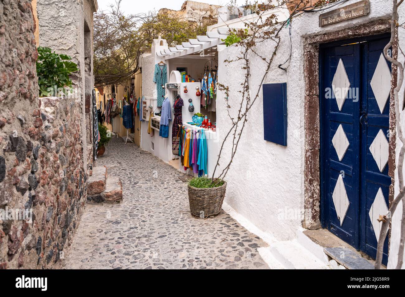Oia, Santorini, Grece, 2022 aprile – vicolo panoramico con un negozio che vende abiti colorati e prodotti artigianali Foto Stock