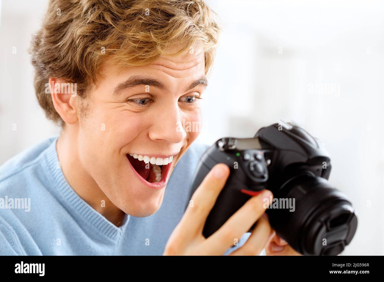 I rischi si ripagano. Scatto di un giovane uomo con la sua fotocamera digitale a casa. Foto Stock