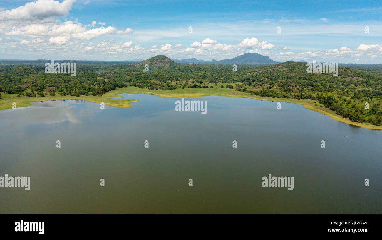 Drone aereo di paesaggio tropicale con lago e valle con foresta tropicale. Lago Sorabora, Sri Lanka. Foto Stock