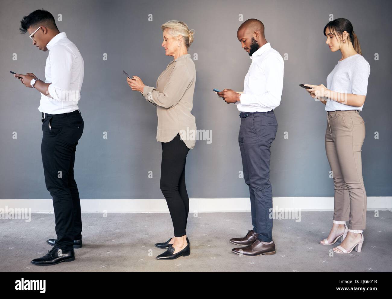 Raggiungerete i vostri obiettivi con l'aiuto degli altri. Foto di un gruppo di giovani aziende che utilizzano dispositivi digitali mentre aspettano in fila. Foto Stock